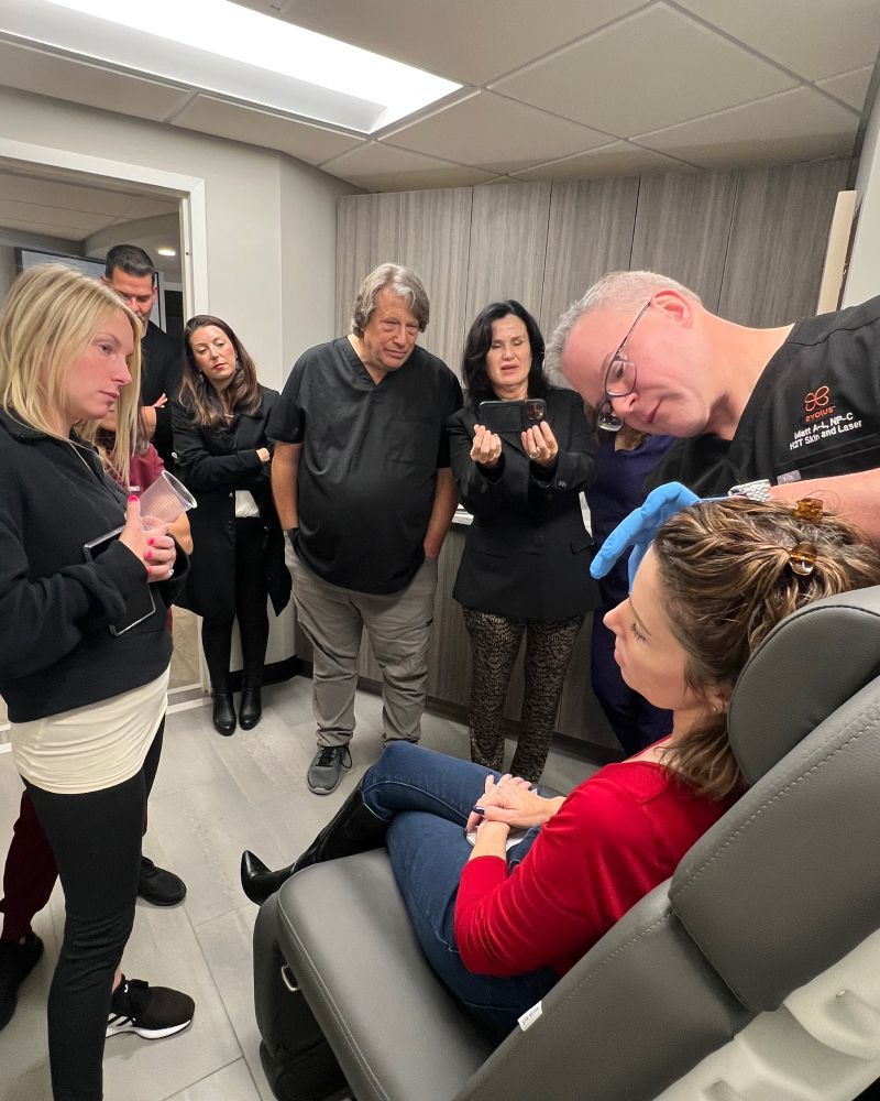 Matt Azulay-LaFever with students attending a patient model in a med spa chair